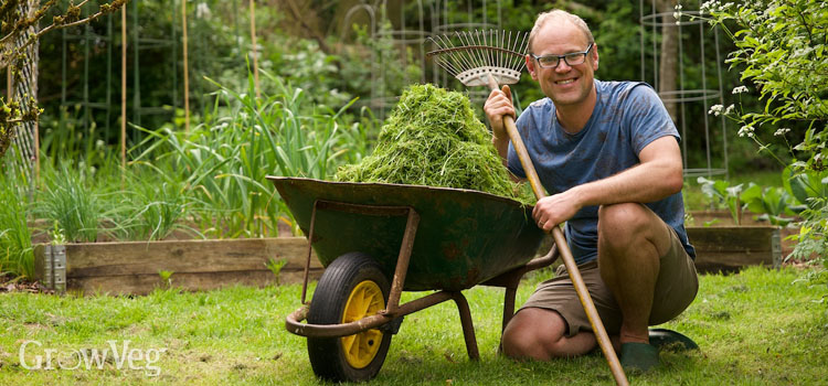 Ben Vanheems with a wheelbarrow full of grass clippings